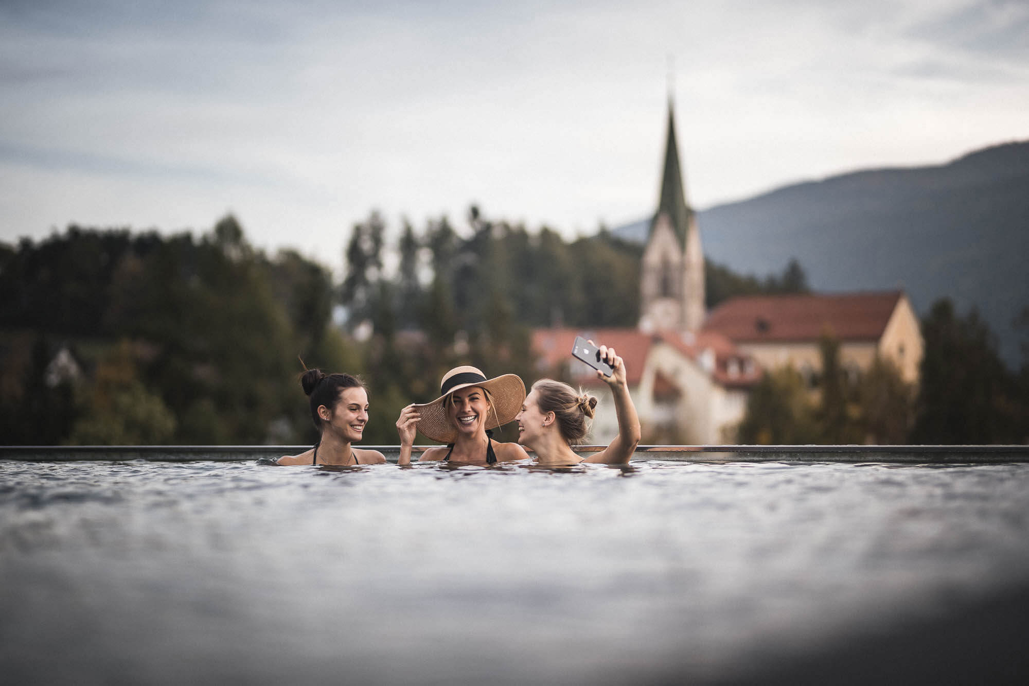 Three friends taking a photo in the outdoor pool - Hotel Terentnerhof