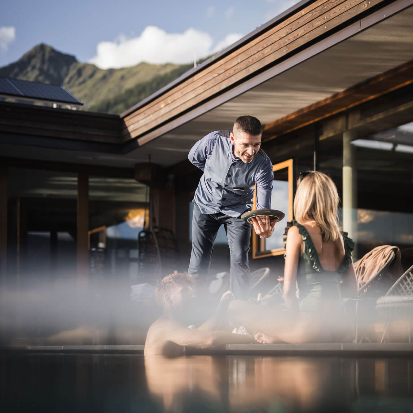 Included services - Woman & man are served by waiters at the pool - Hotel Terentnerhof