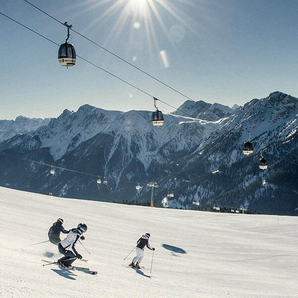 Piste mit Skifahrer vor weißer Bergkulisse - Hotel Terentnerhof